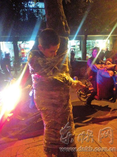 小伙因打赌打输被绑树上半个小时　引来路人围观