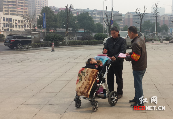 长沙藏珑小区志愿者向市民发放不放烟花爆竹倡议书